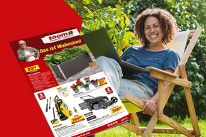 Eine Person sitzt lächelnd im Garten vor einem Prospekt mit Gartenartikeln.